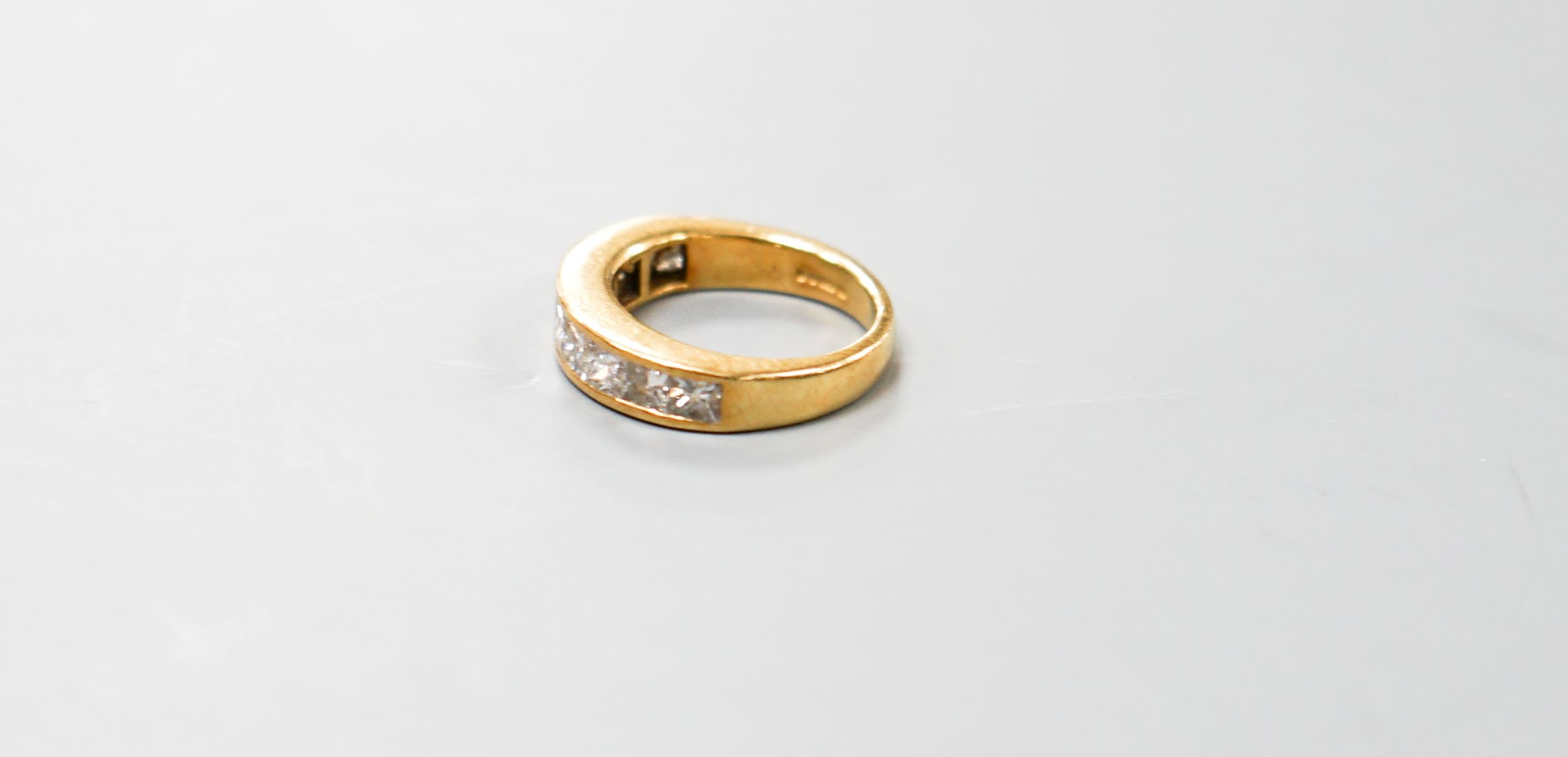 A modern 18ct gold and ten stone Princess cut diamond set half eternity ring, size I, gross 5.4 grams.